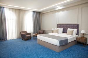 Un pat sau paturi într-o cameră la Grand Hotel Baku Central Park