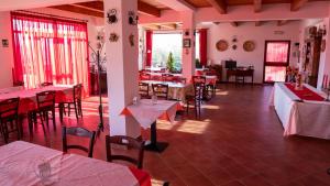um restaurante com mesas e cadeiras vermelhas e uma sala com mesas e cadeiras em Agriturismo Rende em Tarsia