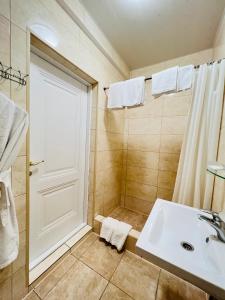 Sergeev Hotel في نيكولايف: حمام مع حوض أبيض ودش