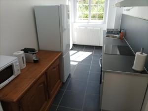 eine Küche mit einem Kühlschrank und einer Arbeitsplatte in der Unterkunft O'Couvent - Appartement 97 m2 - 4 chambres - A514 in Salins-les-Bains