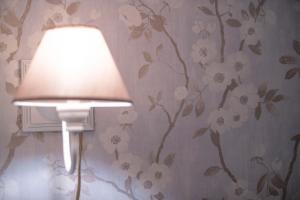 a lamp in a room with flowers on the wall at Chambre de Charme dans maison d'hote "Le Petit Clouet" - Rochecorbon in Rochecorbon