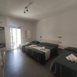 sypialnia z 2 łóżkami i drzwiami na patio w obiekcie Ninfea Tropea City Rooms w Tropei
