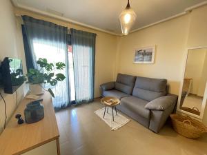 uma sala de estar com um sofá e uma mesa em Apartment Jardines y Mar em Denia