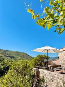 a patio with an umbrella and a table and chairs at Hotel Gattapone in Spoleto