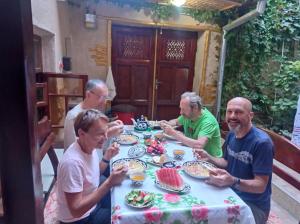 a group of men sitting around a table eating food at Hotel Registon Zargaron in Samarkand