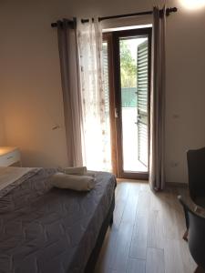 een slaapkamer met een bed en een groot raam bij B&B JoseyMaria in Marina di Camerota