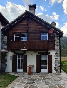 a log house with a balcony on top of it at Fuchs Haus in Formazza