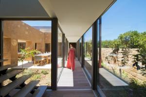 a woman in a red dress walking down a hallway of a house at Conte Marino Villas in Maleme