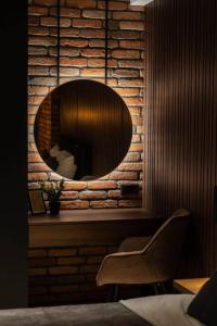 a mirror on a brick wall with a chair at RentWill apartments Loft in Chişinău