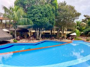 a large swimming pool in a resort with trees at Belo apartamento no Solar Pipa in Pipa +18 photos