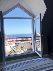 a bedroom with a window with a view of the ocean at Appartement Duplex Perros Guirec 4 pièces 8 personnes in Perros-Guirec