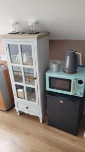 a white cabinet with a microwave on top of it at Salmon island view in Dromineer