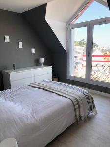 a bedroom with a large bed and a large window at Appartement Duplex Perros Guirec 4 pièces 8 personnes in Perros-Guirec