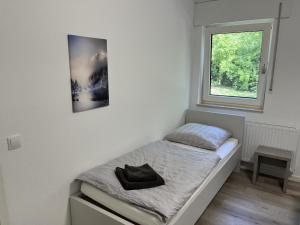 ein kleines Bett in einem Zimmer mit Fenster in der Unterkunft Luxus Apartment III - Garten, Küche, Gym in Reken