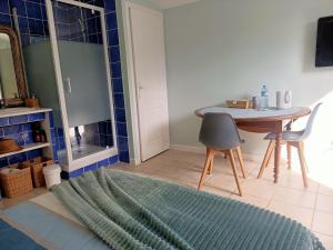 sala de estar con mesa y pared de azulejos azules en La Sornière, en Talmont