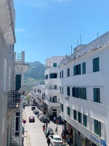 a view of a city street with buildings and cars at Aliens Home in Tétouan