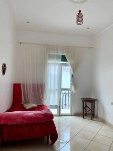 a bedroom with a red bed and a window at Aliens Home in Tétouan