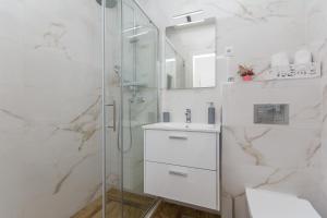 een badkamer met een glazen douche en een wastafel bij Apartment Rivendell in Dubrovnik +23 foto's