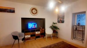 uma sala de estar com televisão e duas cadeiras em Casa Giulia em Luino