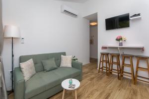 een woonkamer met een groene bank en een tafel bij Apartment Rivendell in Dubrovnik