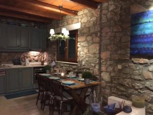 a kitchen with a wooden table and a stone wall at Villa Irene Blue in Krotiri