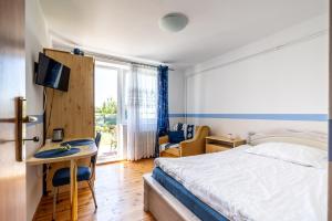 1 dormitorio con cama, escritorio y ventana en Agroturystyka Lubaczówka, en Sarbinowo