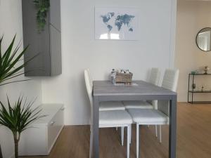 une table à manger avec des chaises blanches et une table dans l'établissement Claro Apartments - Prampolini 12, à Milan