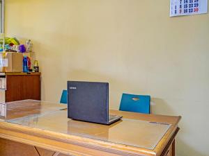 a laptop computer sitting on top of a wooden desk at OYO 91364 Pondok Alfa in Bandung