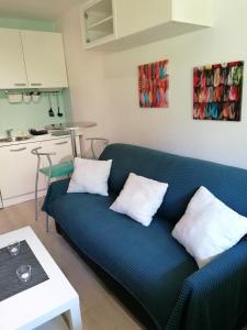 a blue couch with two white pillows in a living room at Studio Central Park in Cannes