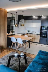 Il comprend une cuisine et un salon avec une table et des chaises. dans l'établissement D Apartments Centrum Prowiantowa II, à Białystok