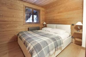 una camera da letto con un letto in una cabina di legno di House Berenice - Chamonix les Praz a Chamonix-Mont-Blanc