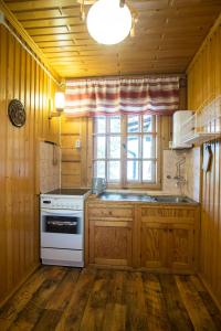 d'une cuisine avec des placards en bois, une cuisinière et une fenêtre. dans l'établissement Gorski dom Gubalowka, à Zakopane