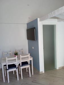 uma sala de jantar com mesa e cadeiras e uma televisão em CASTA DIVA em Sorrento