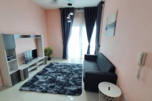 ein Wohnzimmer mit einem Sofa und einem TV in der Unterkunft Serene Stay Minimalist @ Southville City in Kajang