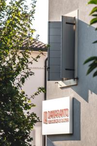 a sign on the side of a building with a window at Damaranto Residenza e Cucina in Soave