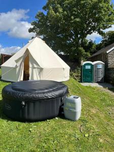 a tent and a mattress and a cooler in a yard at Tipi - Pengarreg in Aberystwyth