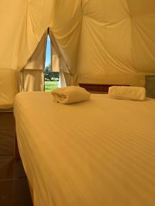 a bed with two white pillows on top of it at Tipi - Pengarreg in Aberystwyth