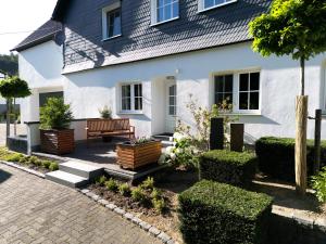 a white house with a bench in front of it at kleine AusZeit in Eslohe