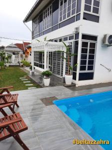a house with a swimming pool in front of it at Beit Azzahra Private Pool Villa at Pantai Batu Hitam in Kuantan