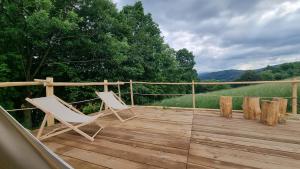 two white chairs sitting on a wooden deck at Tipi Bieszczady Puchary in Hoczew