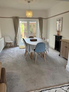 a dining room with a table and chairs at Spacious 4 Bed Rooms, Parking, Garden and Near Parks, Beaches and University in Bournemouth