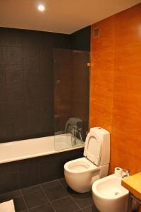 a bathroom with a toilet and a tub and a sink at Miradouro de Lisboa in Lisbon