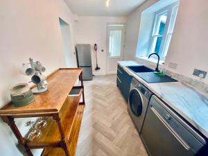 uma cozinha com um balcão, um lavatório e um fogão em The Mynach Annex em Barmouth