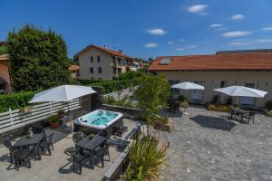 a patio with a hot tub and chairs and umbrellas at La corte di Silvia in Sesto Calende