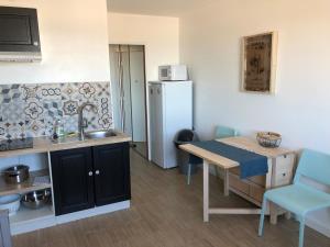una cucina con lavandino, tavolo e frigorifero di L'Évasion - Studio - Vue mer a Calais