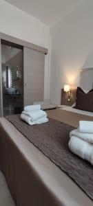 two stacks of towels sitting on top of a bed at B&B Aquavia in Porto Cesareo