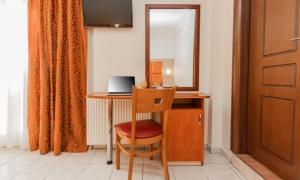 a room with a desk with a chair and a mirror at Hotel Avra in Perea