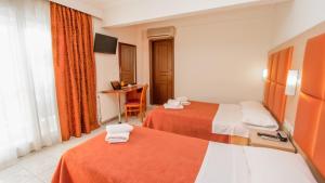 a hotel room with two beds and a desk at Hotel Avra in Perea