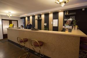 a man standing at a bar in a restaurant at AS Hotel in Göttingen