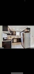 a large kitchen with stainless steel appliances at Lovely 1-bedroom rental unit with free parking in Washington +10 photos